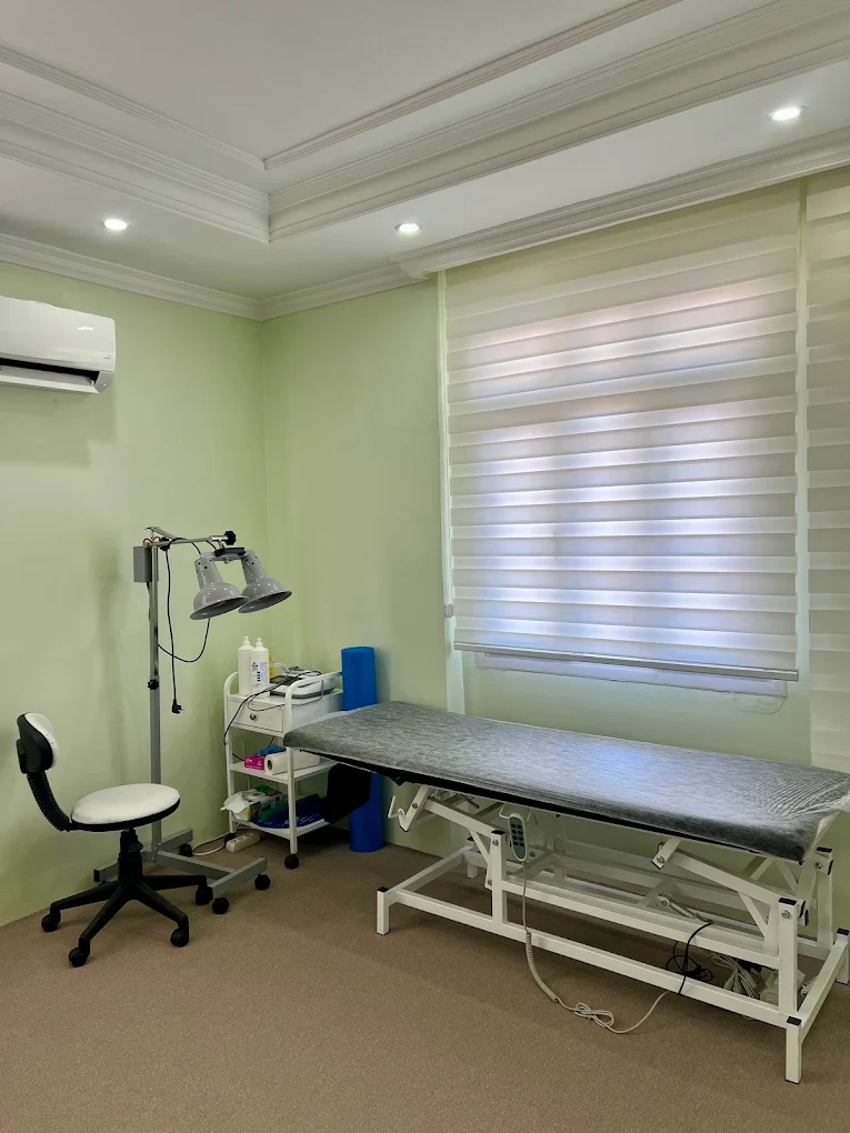 Klinikteki tedavi odası: ayarlanabilir muayene masası ve infraruj cihazı